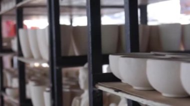 Buda heykeli ve çömlek kaseleri raflarda kayar ve odaklanır sol ve sağ