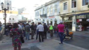 Güneşli bir günde, dükkândan eski binalara, çeşmeye, insanların yanından geçtiği, sırtını duvara dayayıp dinlenen bir çocuğa, soldan sağa, soldan sağa doğru uzanan....