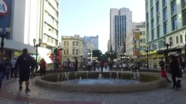 İnsanlar çeşmenin yanından geçerken yürüyorlar, ileri doğru yürüyorlar..