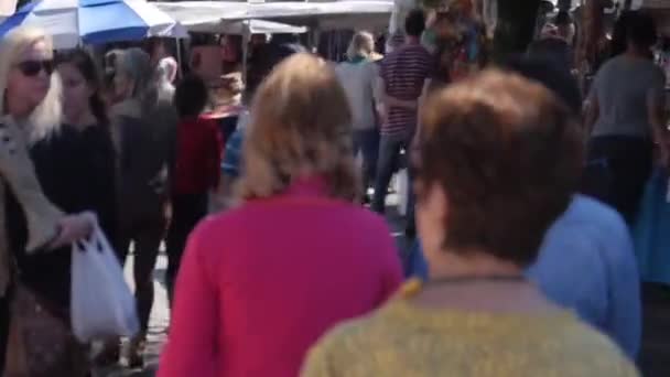 人が後ろから市場の近くを歩く ズームそれから静的な — ストック動画