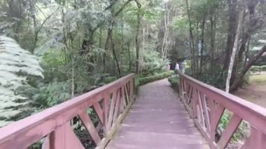 Crossing Brigde Leading To Cobbles Alley Way Surrounded By Flora - Slide Forward.