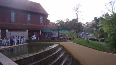 Binanın yakınında oturan insanların önündeki su kaynağındaki merdivenler - Pan - Sağdan sola.