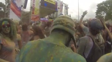 Man Covered By Green Colored Powder Jumping And Dancing In Crowd In Front Of Stage - Static.