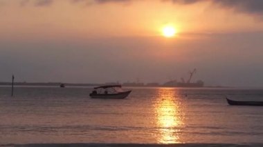 Günbatımının Altında Siyah Işık Altındaki Tekneler ve Denizdeki Yansıması.
