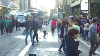 Yoğun caddede sakallı ve büyük kabarcıklar çıkaran insanların yanından geçmek - yavaş hareket