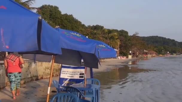 Pessoa Andando Perto Tons Sol Azul Cadeiras Para Vista Praia — Vídeo de Stock