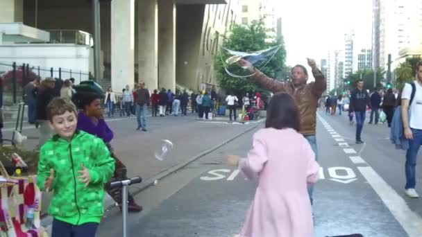 Kids Jumping Excitement Man Making Bubbles Busy Street Static Slow — Stock Video