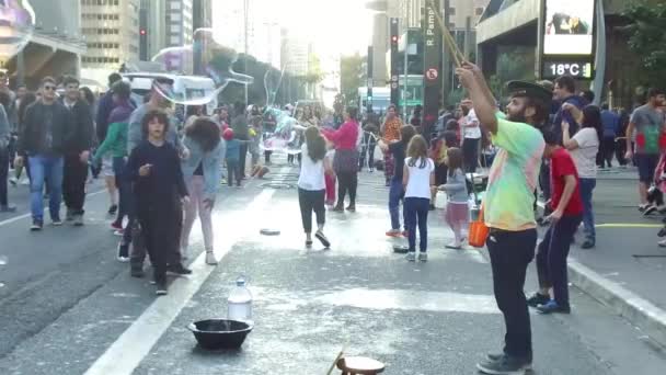 Kleine Jongen Ontzag Lopen Springen Naar Bubbel Barsten Drukke Straat — Stockvideo