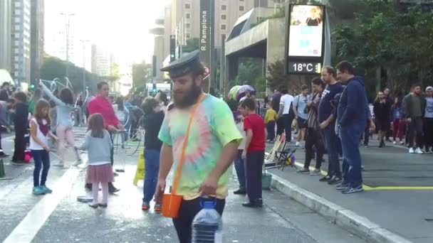 Człowiek Brodą Odkładanie Butelki Wody Otoczony Przez Tłum Bawiący Się — Wideo stockowe