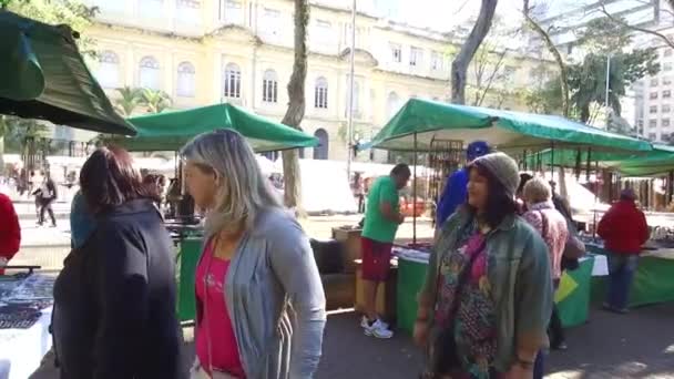 Mensen Kijken Naar Marktkraam Pan Van Rechts Naar Links — Stockvideo