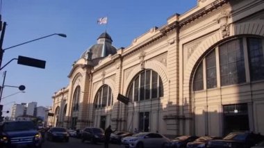 From Cars In The Street To Long Building Main Entry - Pan - Left To Right