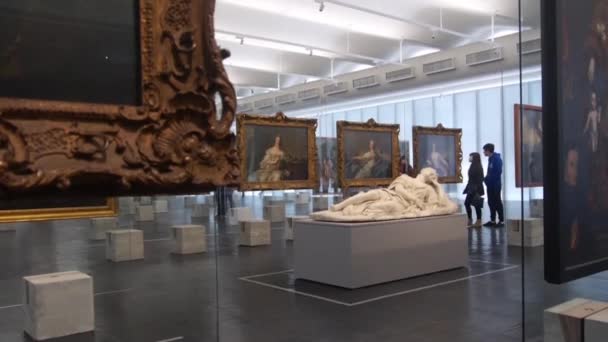 Casal Andando Perto Estátua Homem Deitado Rodeado Por Pinturas Museu — Vídeo de Stock