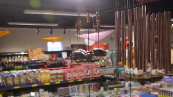 Windspiele Hängen Einem Geschäft Mit Verschwommenen Bunten Ladenregalen Rücken Nahaufnahme — Stockvideo