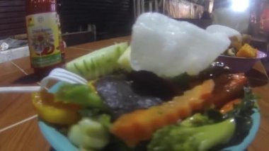 Ramen ve karides parçalı tabaklar soldan sağa kayıyor.