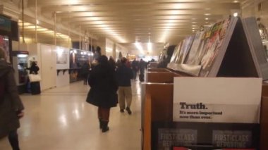 People Walking Past Magazines On Stand - Slide - Right To Left.