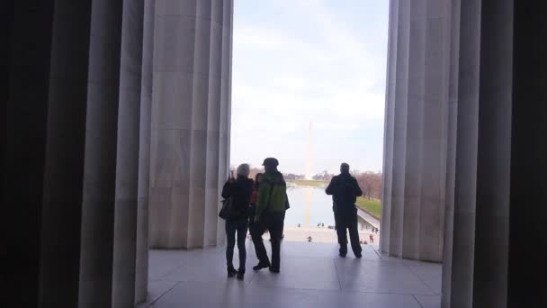 Mensen Die Tussen Pilaren Door Lopen — Stockvideo