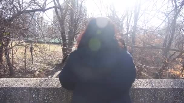 阳光照耀着冬季观看干枯树木的妇女 — 图库视频影像