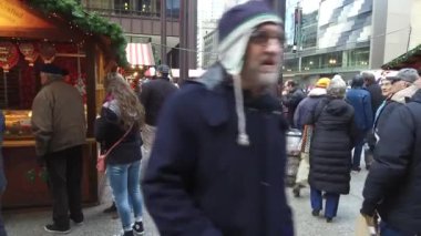 Woman Taking Pictures With Her Phone Surrounded By People In Christmas Market - Pan - Left To Right