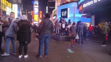  People In Lit Up Street At Night - Pan - Right To Left