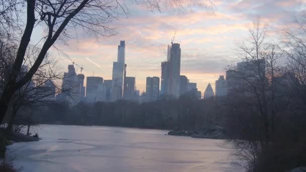 都市のスカイラインと水源の上の日没の空の雲 — ストック動画