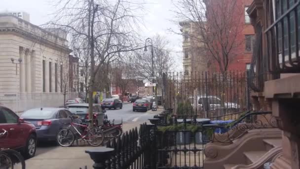 自転車や車で通りの前に家とフェンス — ストック動画