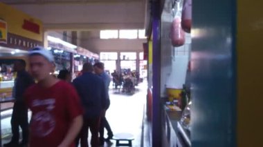 Marketin yakınındaki insanlar siyah ışıkta durup sağdan sola kayıyor..
