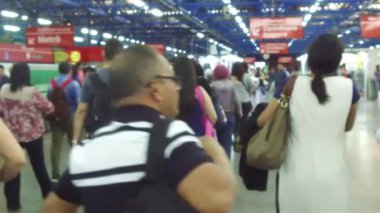 Metro istasyonundaki insanlarla çevrili.