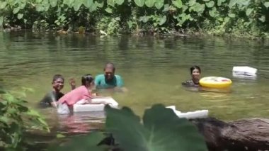 Flora yakınlarındaki bir gölde aile el sallıyor ve şamandırayla oynuyor.