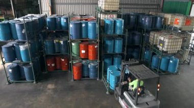 Bir fabrikada çatal-kaldırma 4 fıçıyı raftan çıkarıyor. 