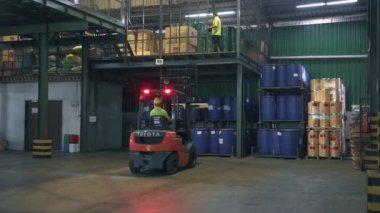 Bir fabrikadaki ikinci kata ahşap bir paleti kaldırıyorum. 