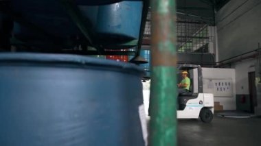 Bir fabrikada çatal-kaldırma 4 fıçıyı raftan çıkarıyor.