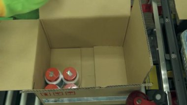 Bir Kutuyu Kırmızı Kapaklı Şişelerle Dolduran Kişi