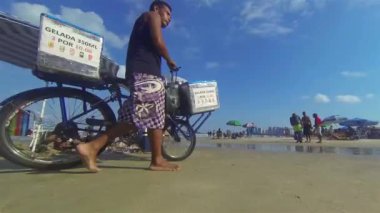 İnsanlar sahilde yürüyor ve dinleniyor.