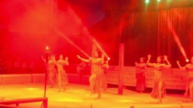 Sirkte kırmızı ışıklarla dans eden kızlar