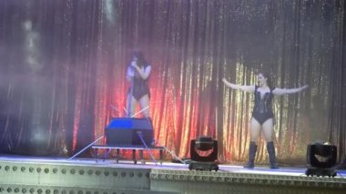 Siyah kısa elbiseli ve kılıçlı iki güzel Brezilyalı Sihirli numaralar yapıyor