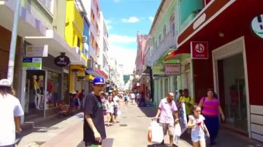 Florianopolis, Brezilya 'da kalabalık bir şehir merkezinde mavi şapkalı bir adam yürüyor..