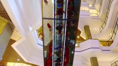 Yürüyen merdivene çıkan insanların aynadaki yansıması.