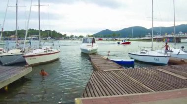 Brazilian boys jumping into a lake from an anchored boat