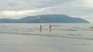 Kumsalda denize doğru yürüyen çift.