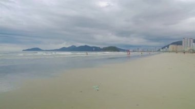 A big sandy beach with silhoutte of mountains on an island - static.