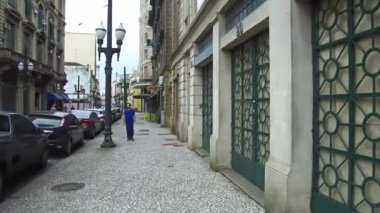 Man in blue shirt Walking on the pebble streets of downtown in the city of Santos.