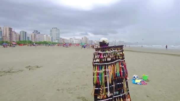 男は彼の製品と一緒に歩いてビーチで販売する — ストック動画