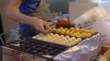 Johor Bahru 'daki açık hava pazarında takoyaki yapan Çinli bir adam.