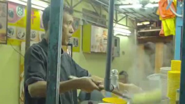 Bir şef tabakta erişte çevirir - yan manzara.