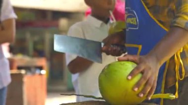 Hindistan cevizi kesen Asyalı bir adamın ön görüntüsü..