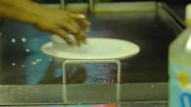 Hintli adamın ızgarada krep yaptığı yakın plan.