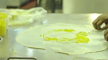 Hintli adam, Kuala lumpur 'da güzel bir restoranda roti canai için yumurtayla hamuru kapatıyor.