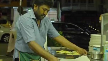 Hintli adam Kuala lumpur 'da bir restoranda roti canai için para çeviriyor.