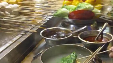  Adam gece pazarındaki bir buharlı tekne tezgahında çubuk taşıyor..