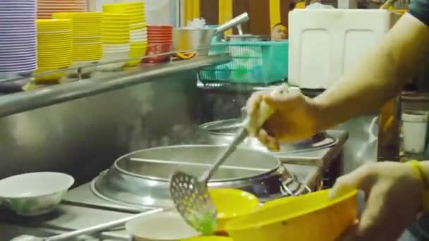 黄色の牛肉麺スープカップに野菜を注ぐ男 — ストック動画